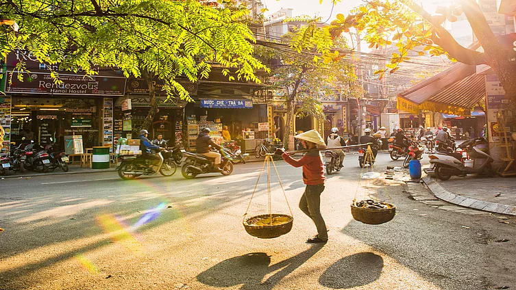 Hà Nội, Việt Nam – Ngày 13 tháng 1 năm 2015: Một người bán hàng đang bước vào khu phố cổ.
